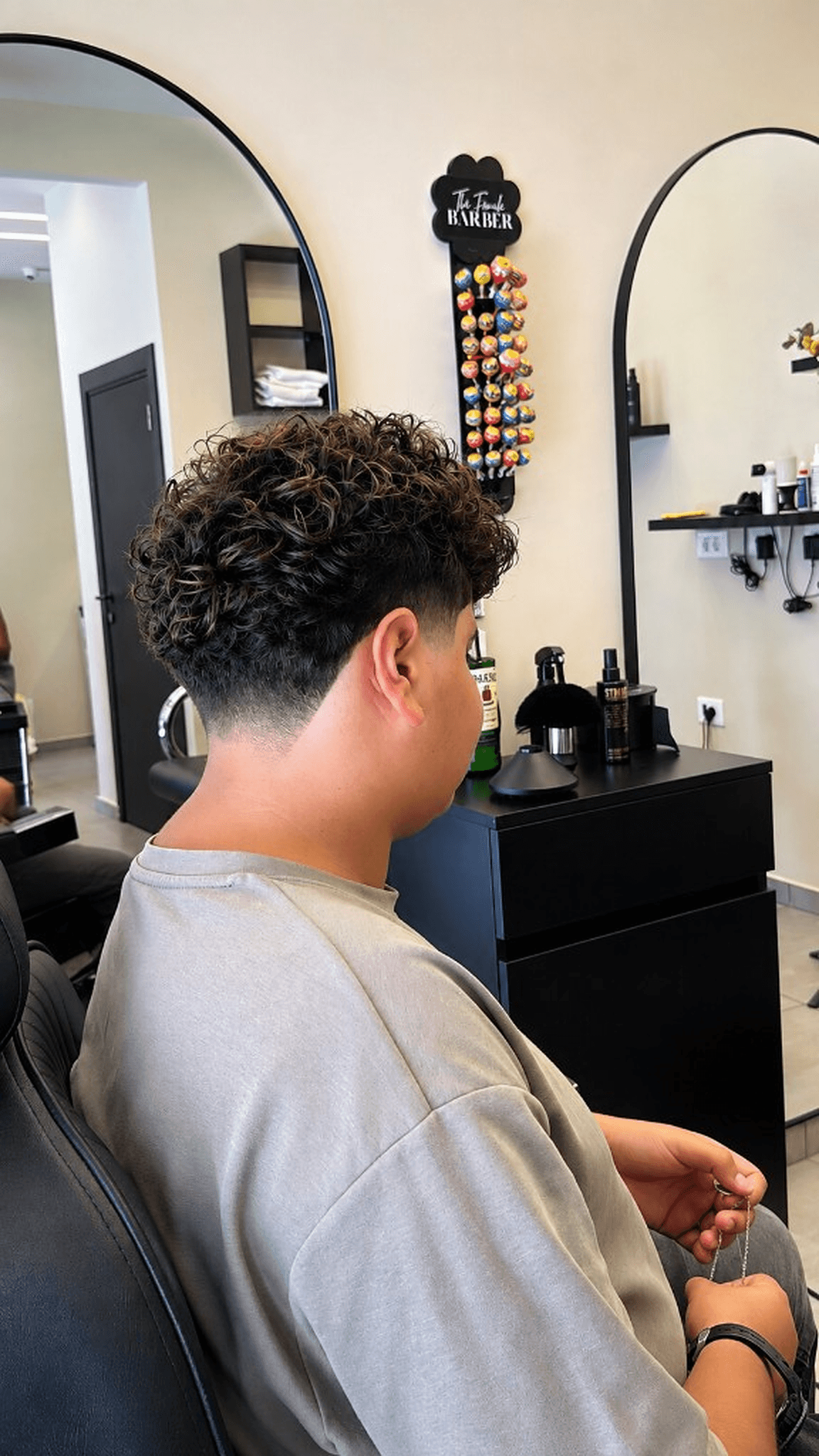 Client with curly taper fade in the studio chair